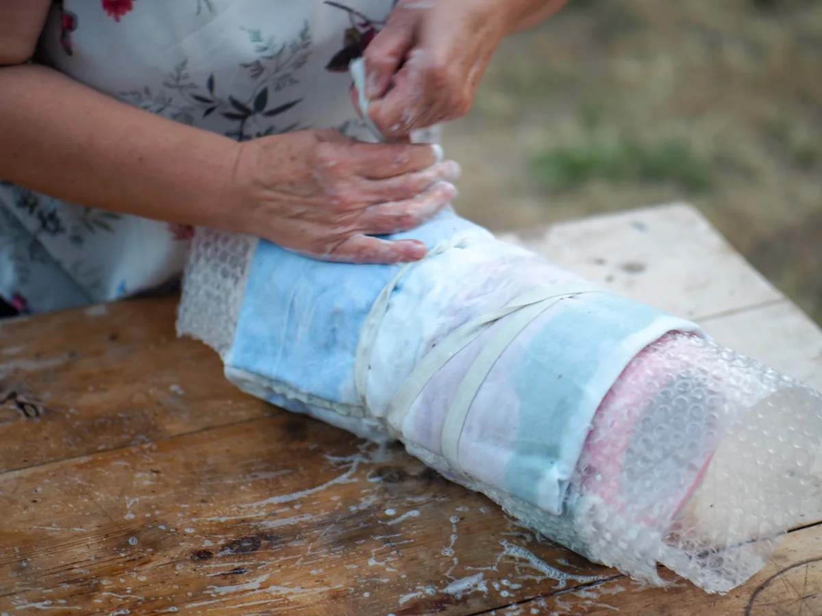 La pieza de fieltro mojado enrollada para continuar el afieltrado